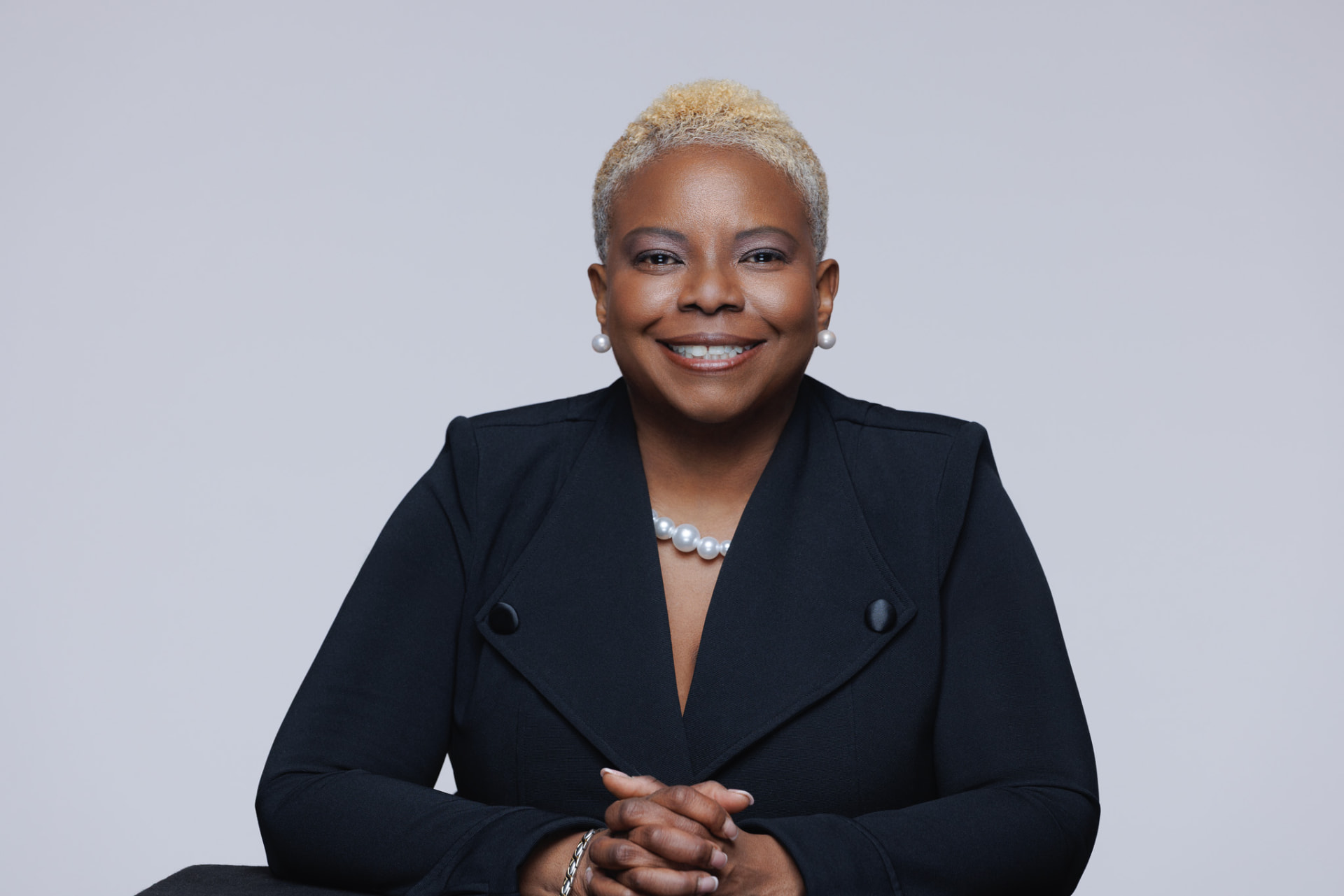 Robben Washington seated with her hands folded